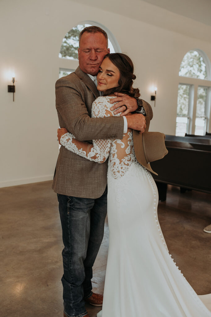 the stunning bride and her father sharing a hug before the ceremony 