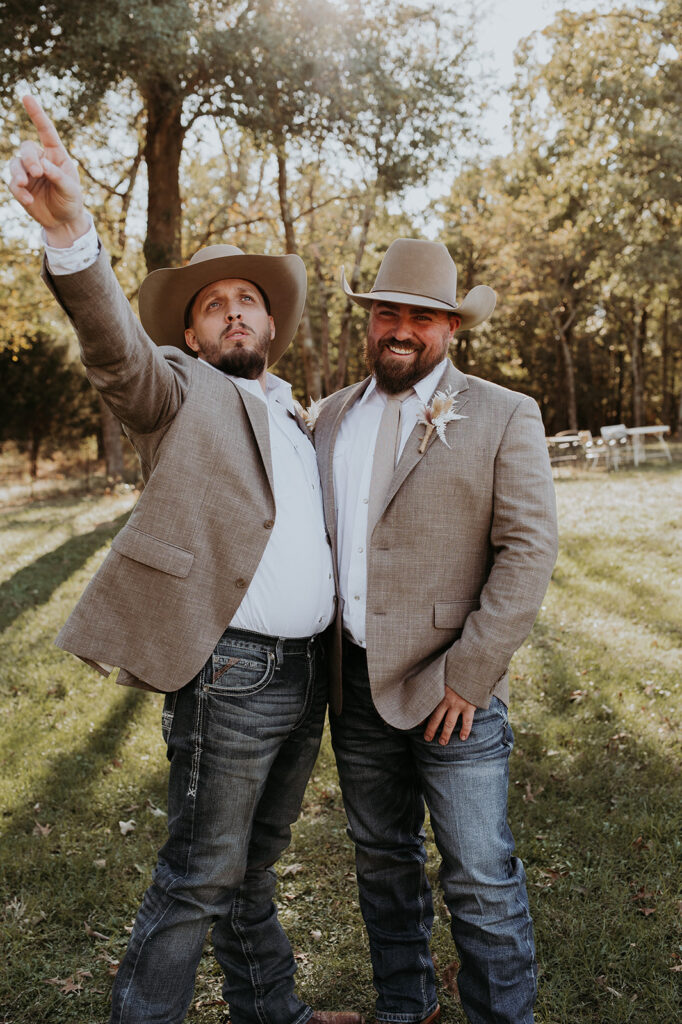 Groom and his friends doing funny poses at his western wedding
