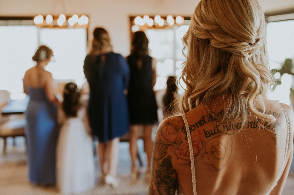 bride standing behind her bridesmaids before their first look at their beautiful wedding | Kelli and Adam's Wedding Day At Bethel Rock, Texas