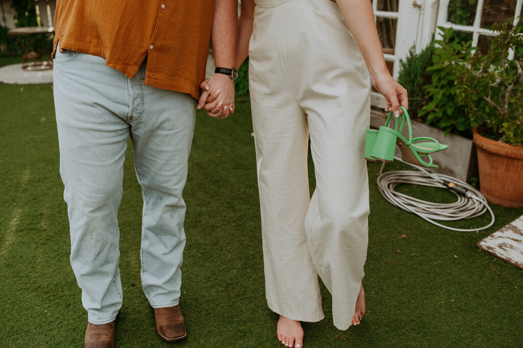 couple holding hands at their engagement photos at house of dirt
