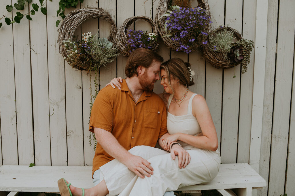 gorgeous couple seating at house of dirt during their engagement session