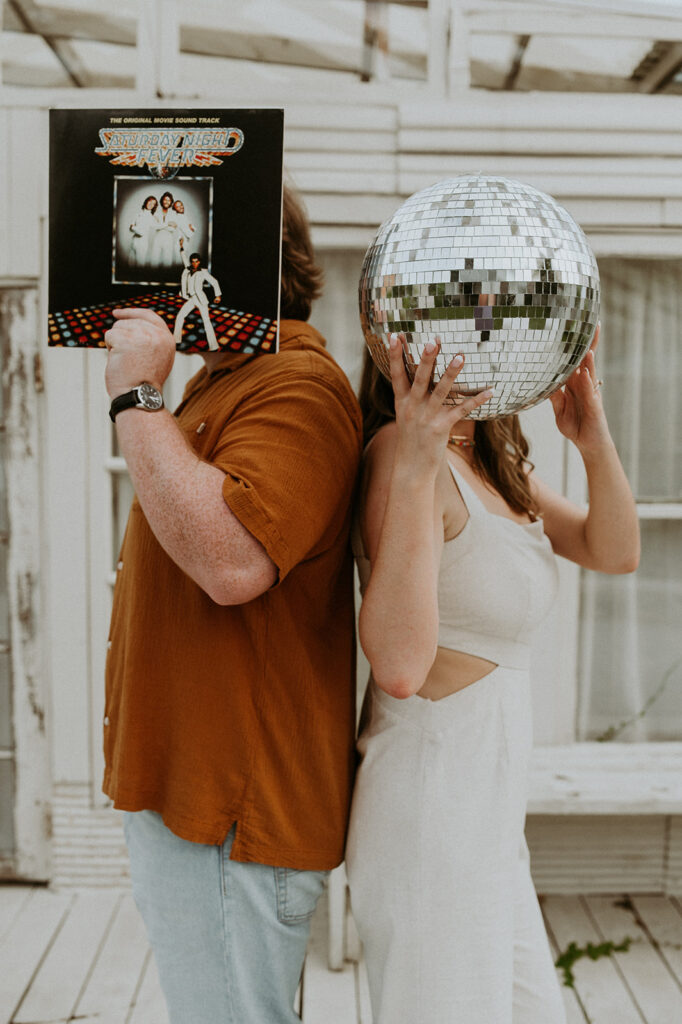 Couple during their engagement session with a disco ball and a record player 