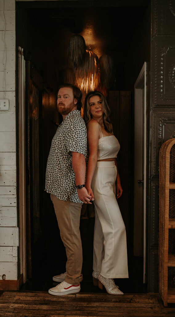 Couple back to back looking at the camera during their engagement session