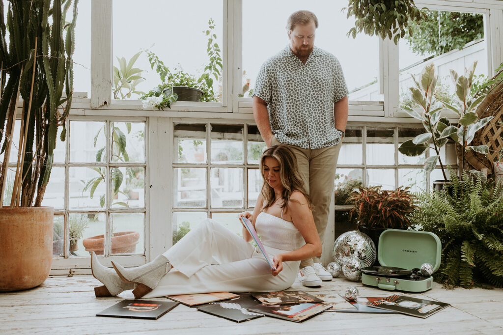 Couple at house of dirt with a record player during their unique engagement photoshoot 