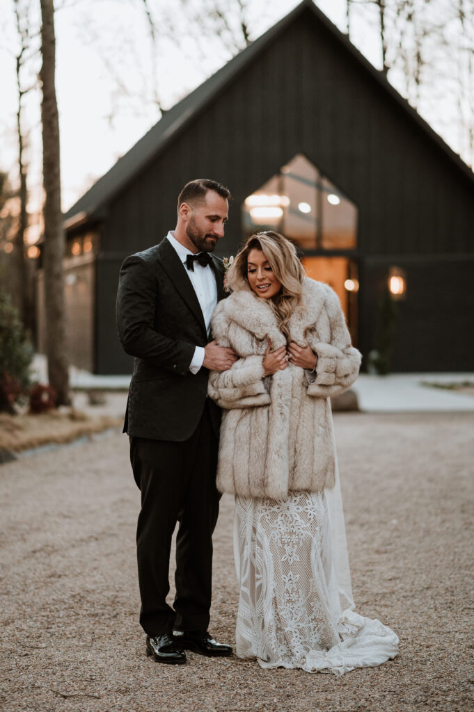 groom hugging the bride wearing a coat on their romantic winter elopement day 