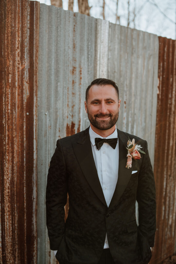 Groom smiling at the camera during his winter elopement