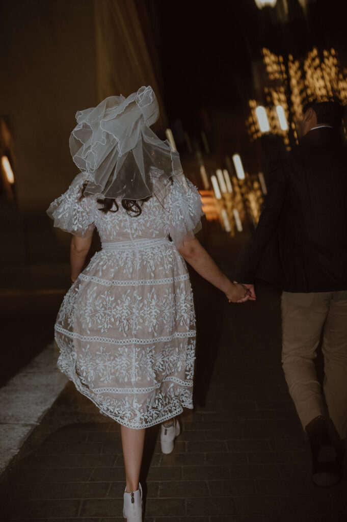 couple walking downtown holding hands during their engagement session 