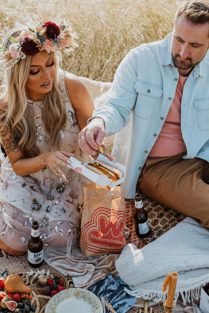 couple eating hotdogs during their unique engagement session 