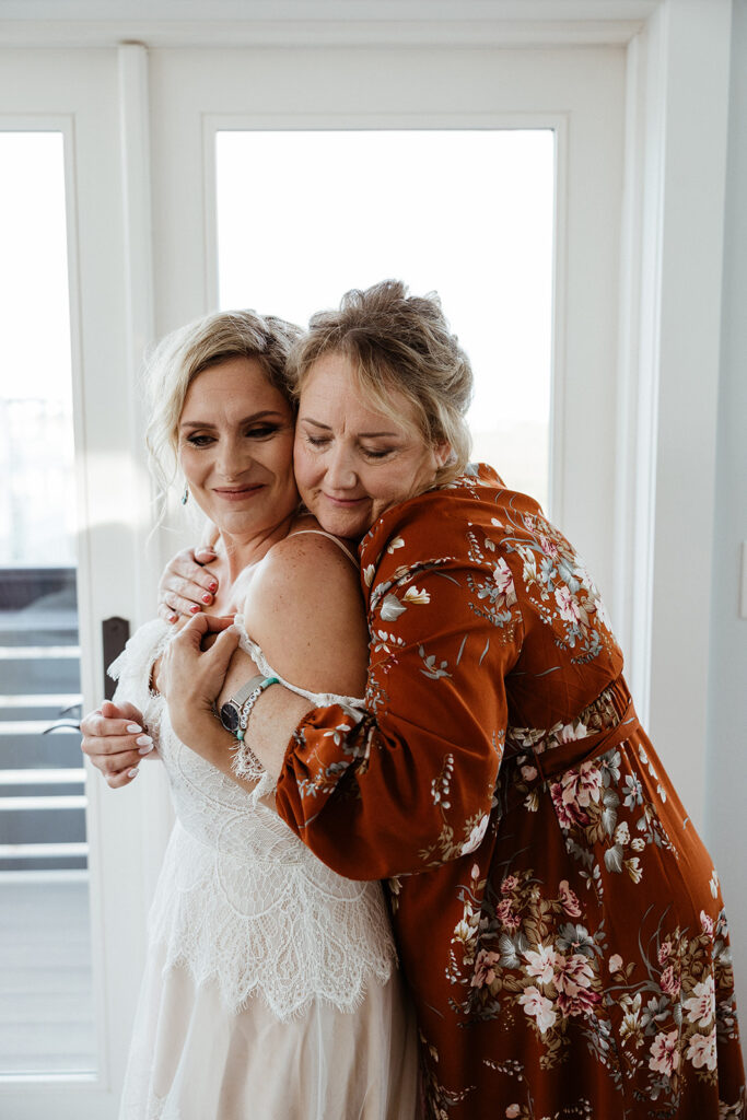 bride and her mom hugging before the wedding ceremony 