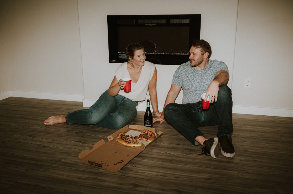 couple eating pizza during their first home session | at home couples session