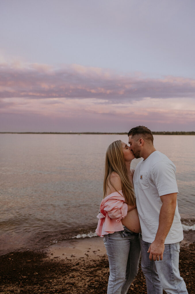 soon to be parents kissing during their summer maternity session