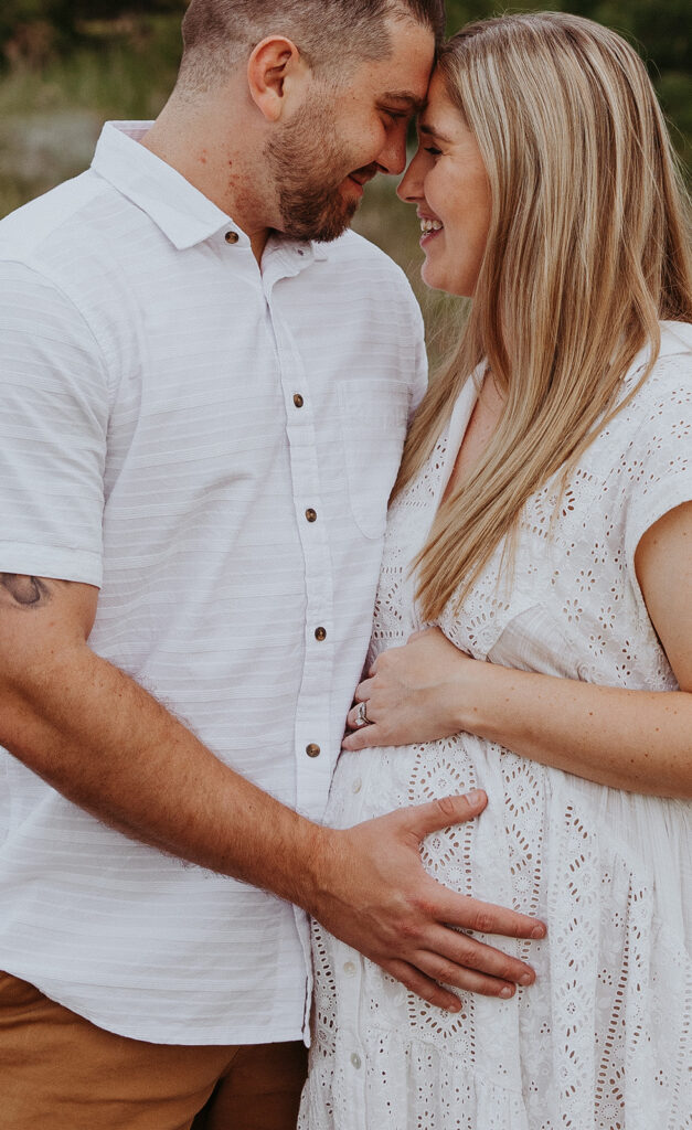 couple looking at each other during their summer maternity session